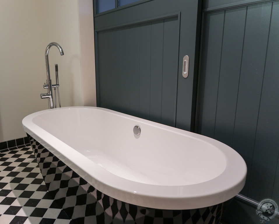 A gorgeous tub just behind the sliding farmhouse doors