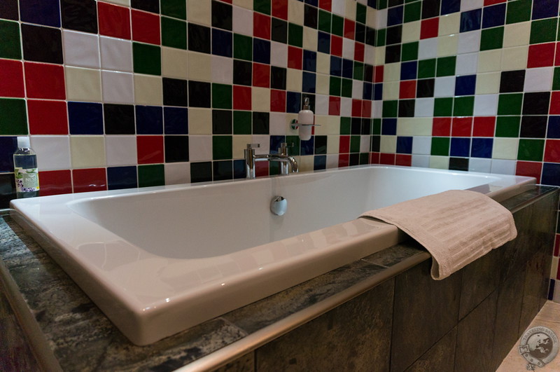 A huge tub and shower lie within the bathroom