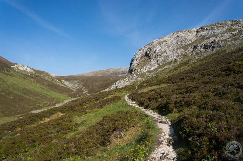 We find the path as it leads up to a rocky eminence